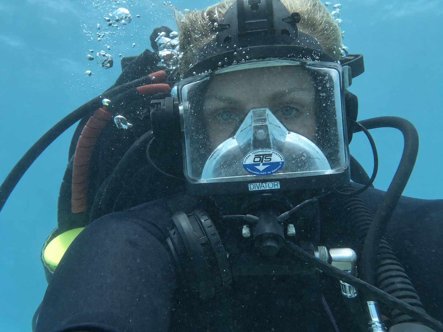 A diver underwater wearing a full-face diving mask